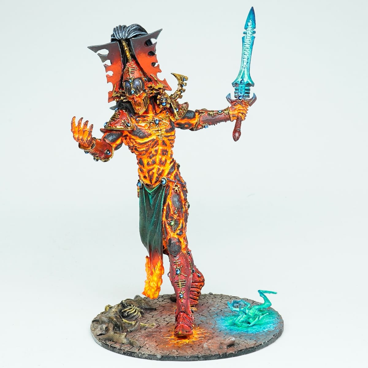 L’Avatar de Khaine : peau en fusion aux fissures orange incandescentes, tenant une épée bleue