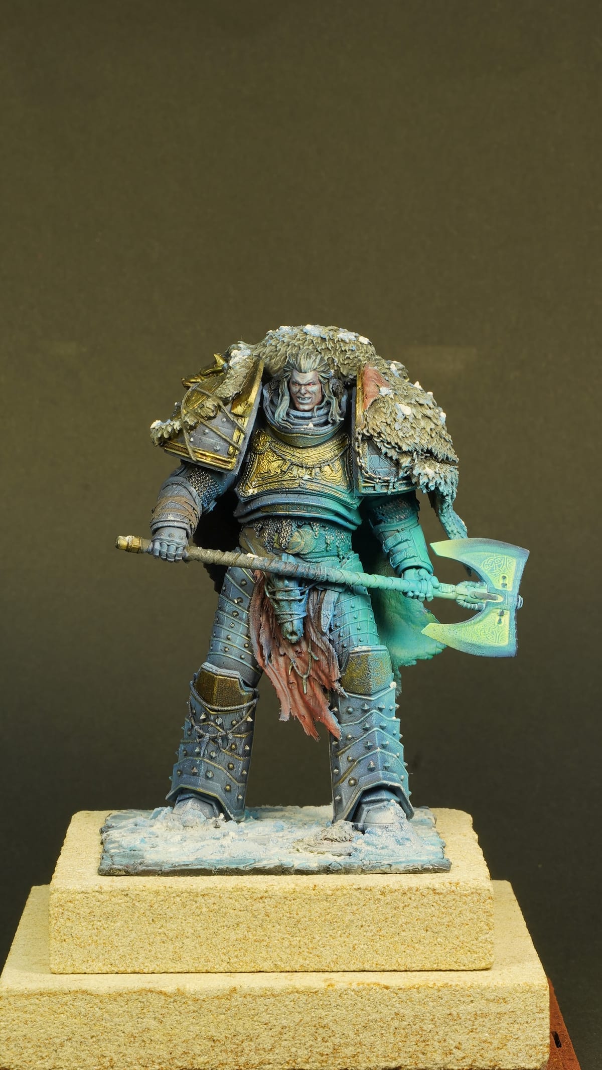 A warrior in blue-grey power armour with fur and an axe
