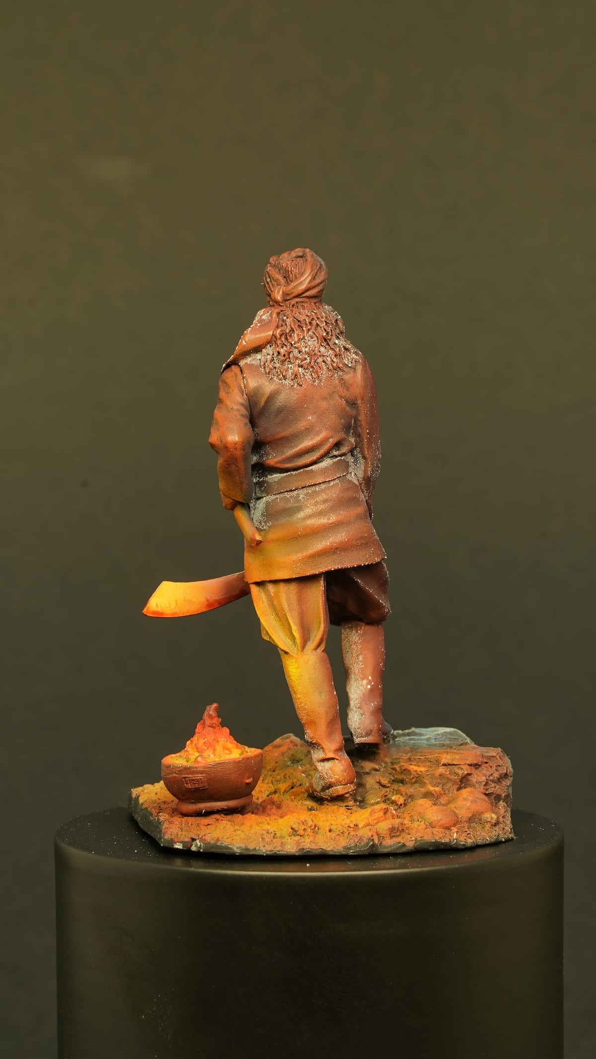 The figure from behind, the brazier glowing