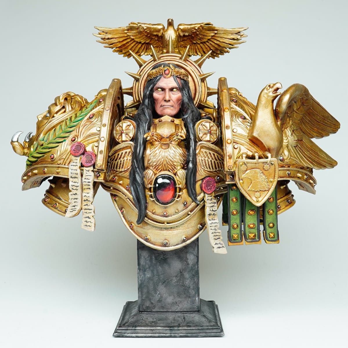 Busto del Emperador de la Humanidad con una armadura dorada ornamentada y una cresta de águila