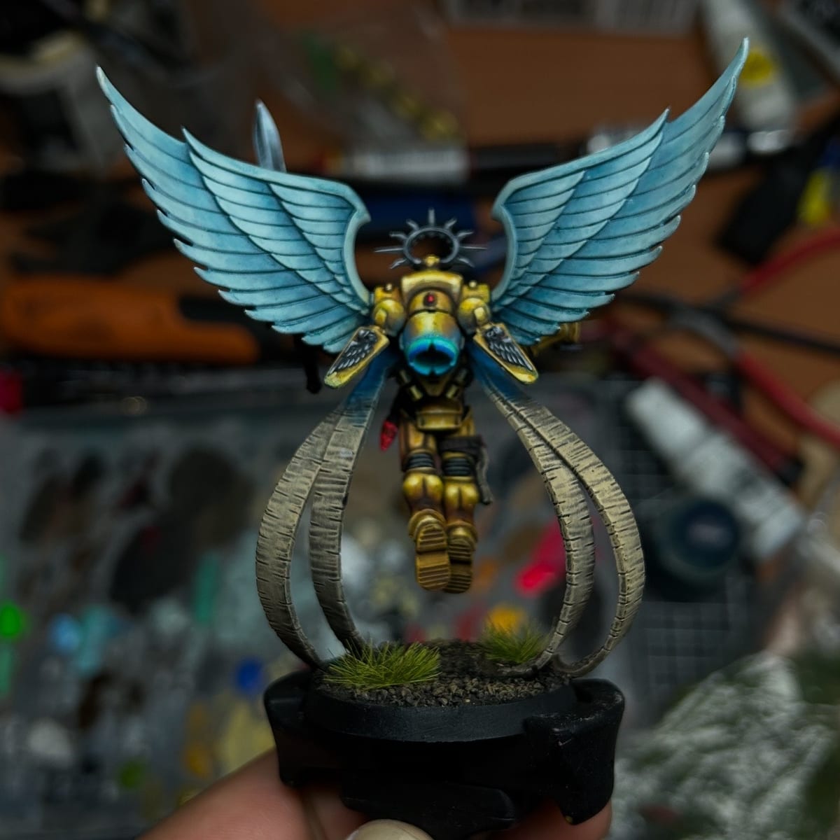 A golden figure with blue wings above a glass dome