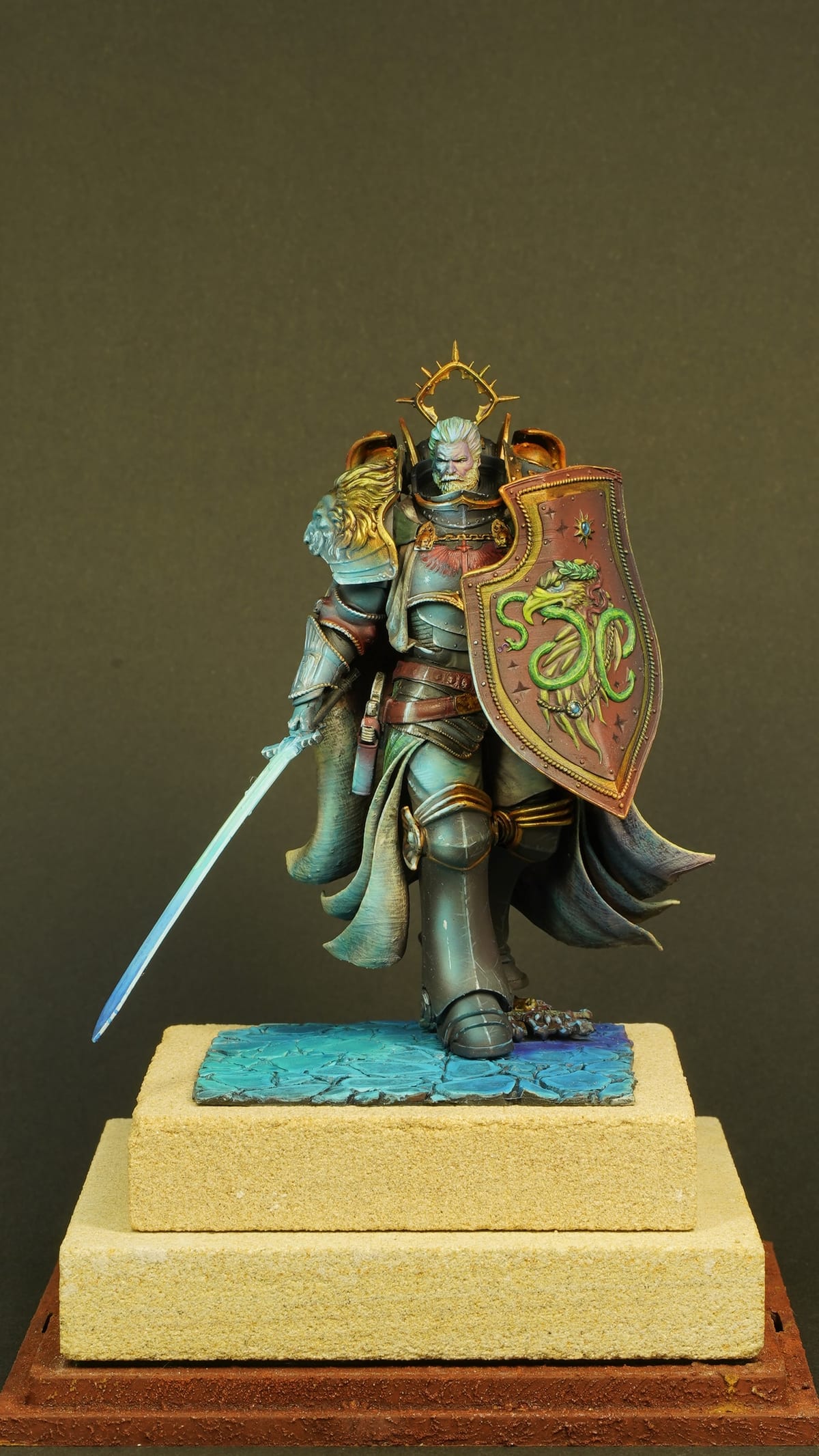 An armoured knight with a sword and a decorated shield, on a stepped base