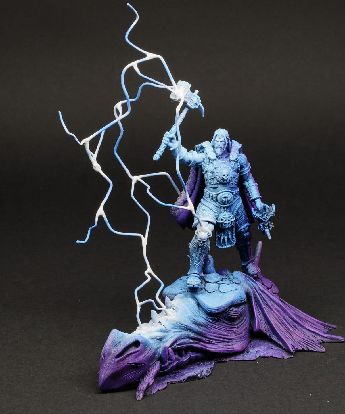 A robed figure in blue and violet, wreathed in lightning, on a dark background