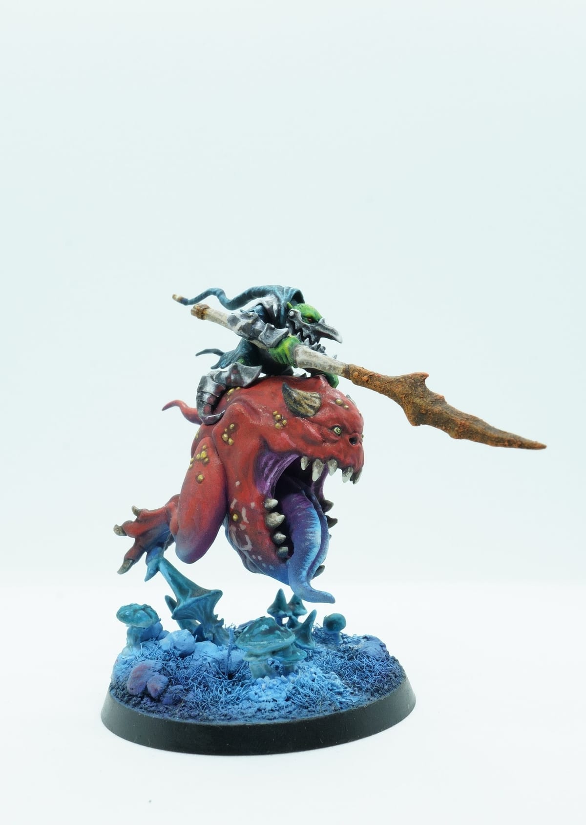 A goblin riding a huge red squig over a blue water base