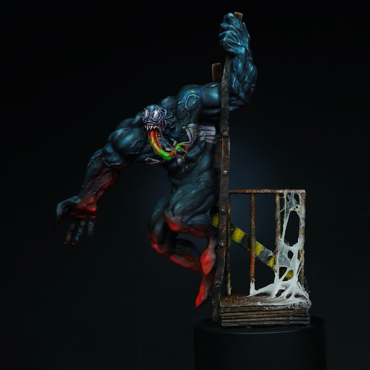 Venom saltando desde un poste cubierto de telaraña, con el cuerpo azul oscuro y luces rojas